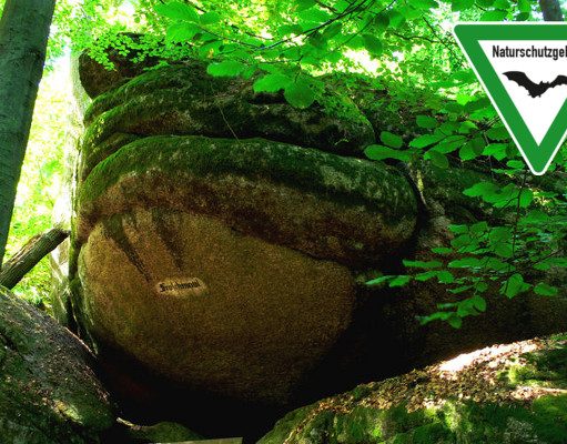 The Froschmaul rock formation in Falkenstein Schlosspark, Germany, with nature reserve sign