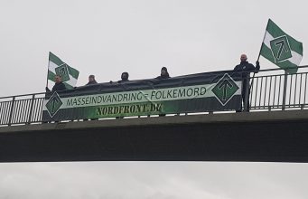 Nordic Resistance Movement activists hold a “Mass Immigration Is Genocide” banner over a bridge in Denmark
