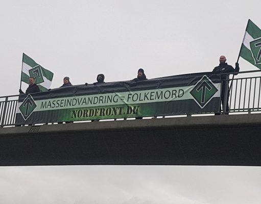 Nordic Resistance Movement activists hold a “Mass Immigration Is Genocide” banner over a bridge in Denmark