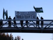 Nest 5 Nordic Resistance Movement activists hold a banner reading “Protect the Children – Crush the Homo Lobby” on a bridge in Borlänge, Sweden