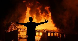 Man in front of burning house