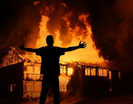 Man in front of burning house
