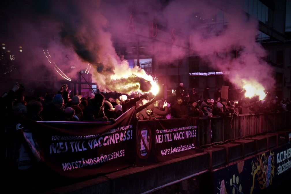 Nordic Resistance Movement activists with flares at anti-vaccine passport demonstration, Stockholm