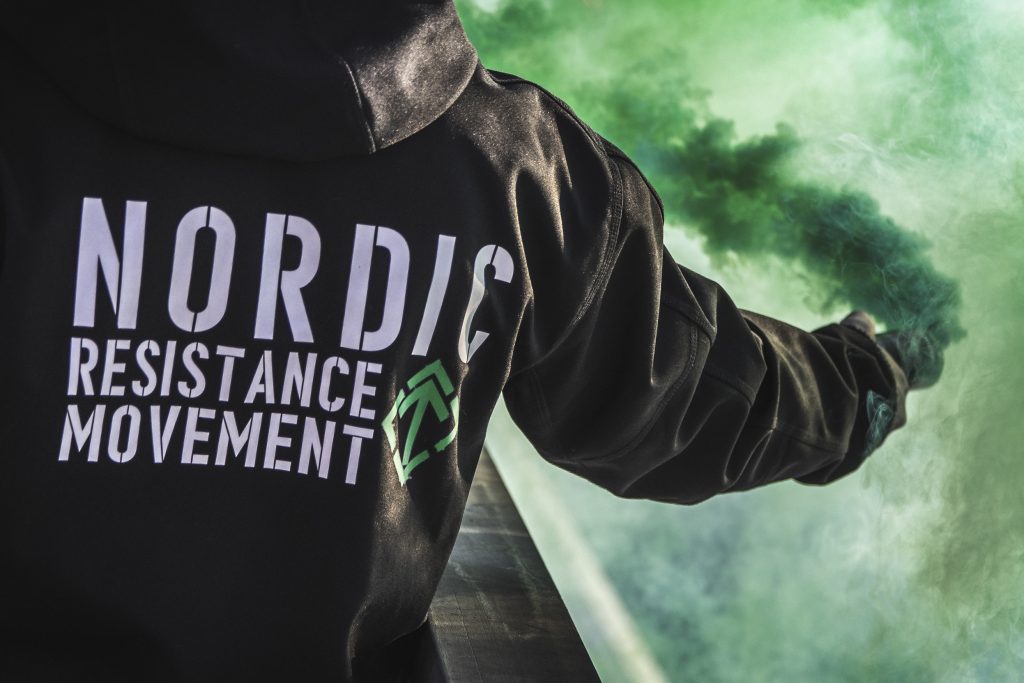 Nordic Resistance Movement activist with green smoke grenade