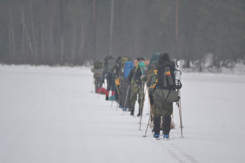 Nordic Resistance Movement activists walking on skis on a frozen lake