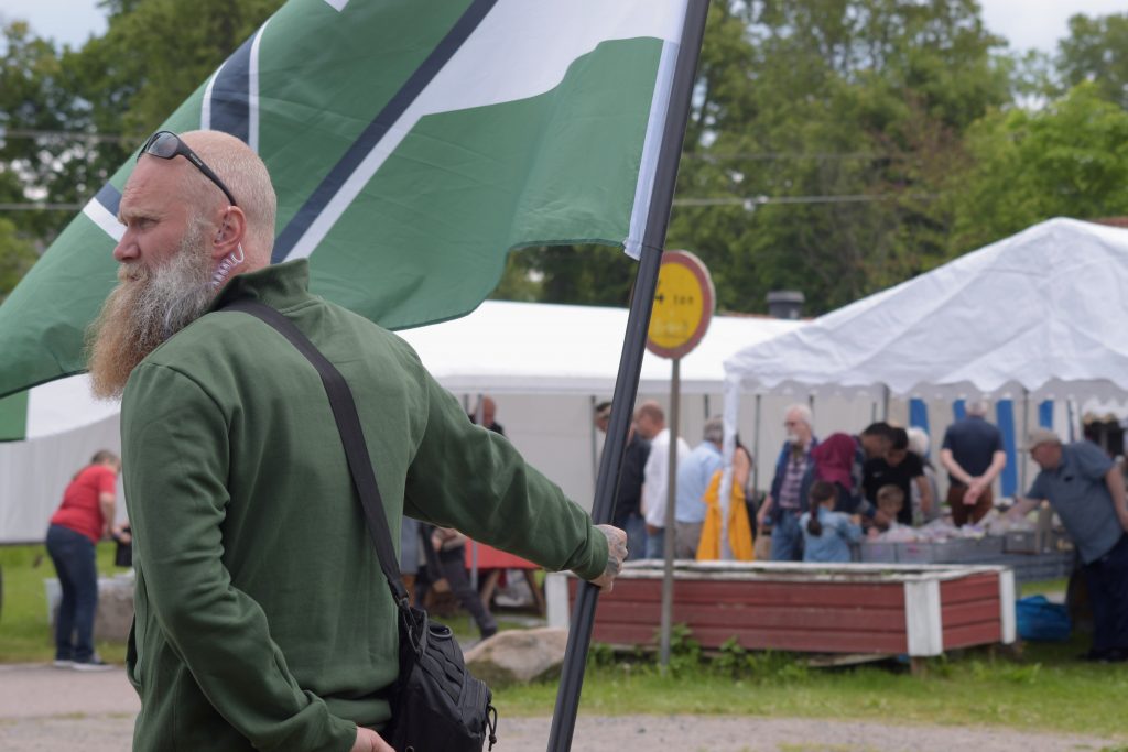 Nordic Resistance Movement activist with Tyr rune flag in Ludvika, Sweden