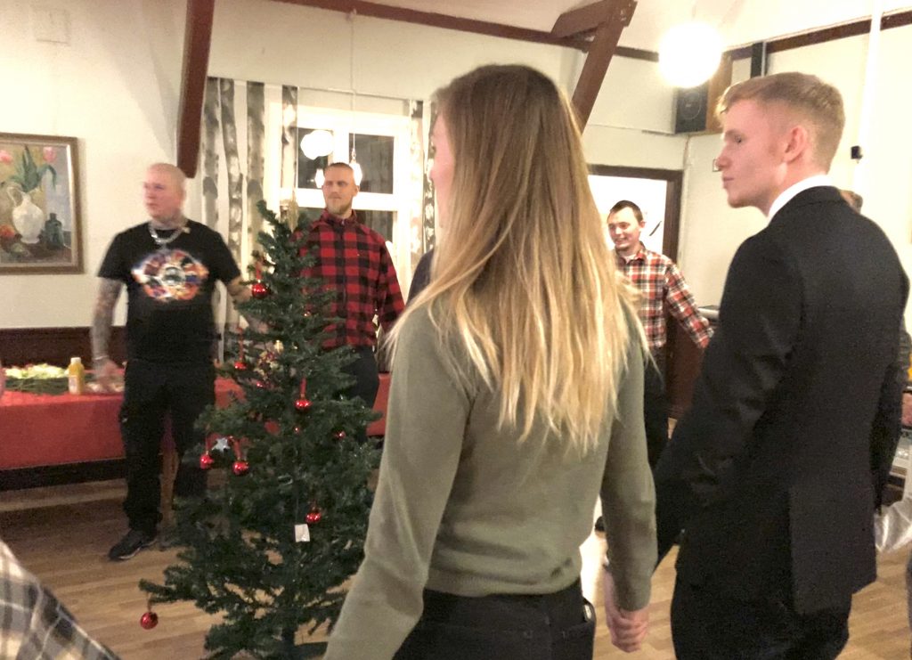 Nordic Resistance Movement members stand around Christmas tree at meeting