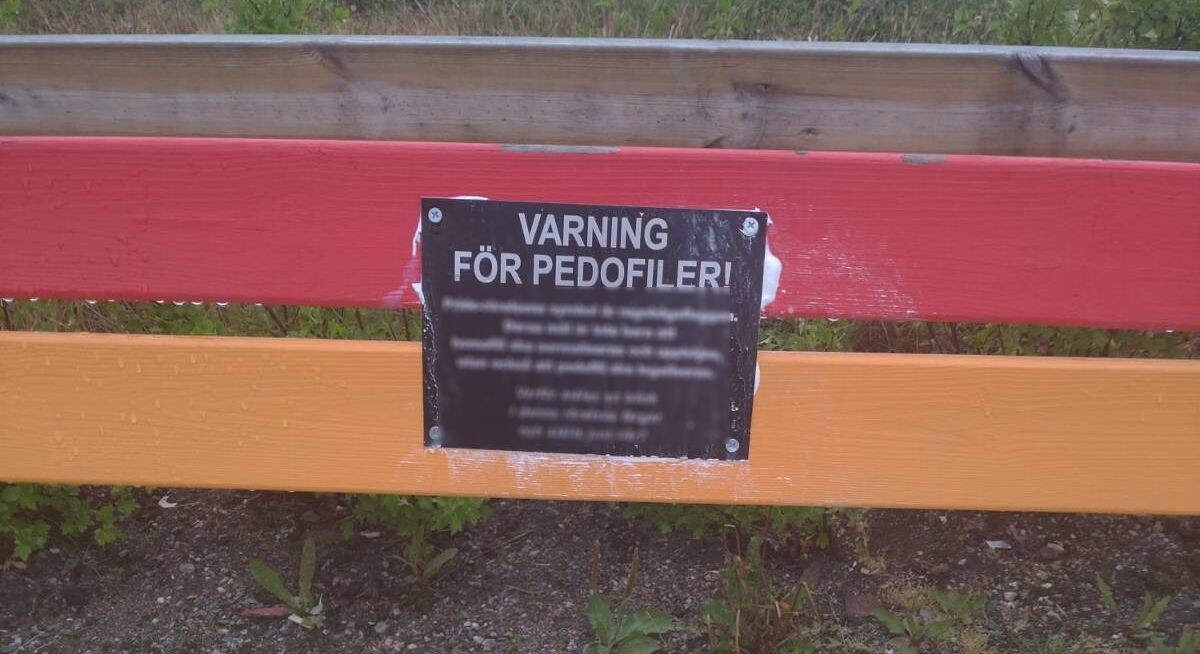 LGBTQP bench affixed with warning sign, Ludvika, Sweden